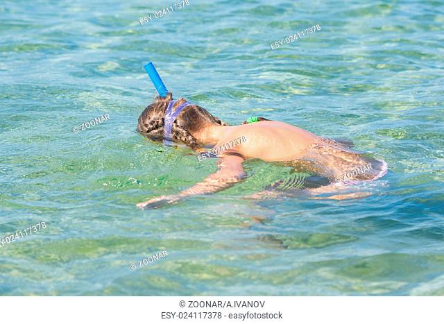 Girl swimming under water with mask and snorkel