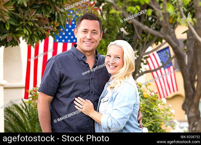 Happy couple in front of houses with american flags