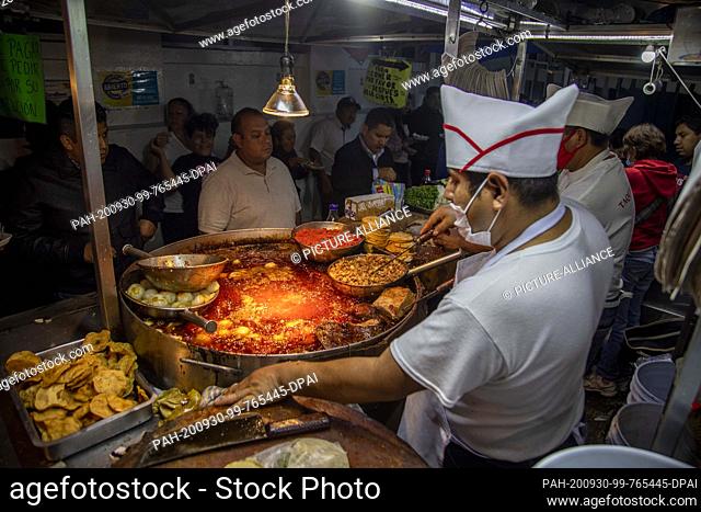 27 August 2020, Mexico, Mexiko-Stadt: Men wait in a diner where take-away tacos are prepared. 70 percent of adults and a third of children and young people in...