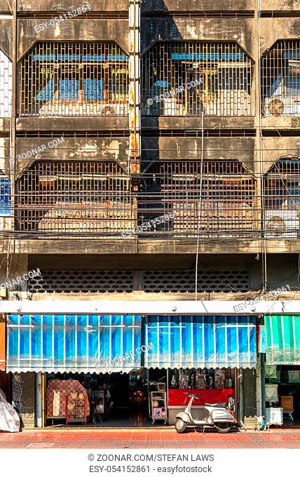 Apartment building in the Chinatown of Bangkok, one of the largest in the world. The windows are all barred. Different shops and stores downstairs of the...