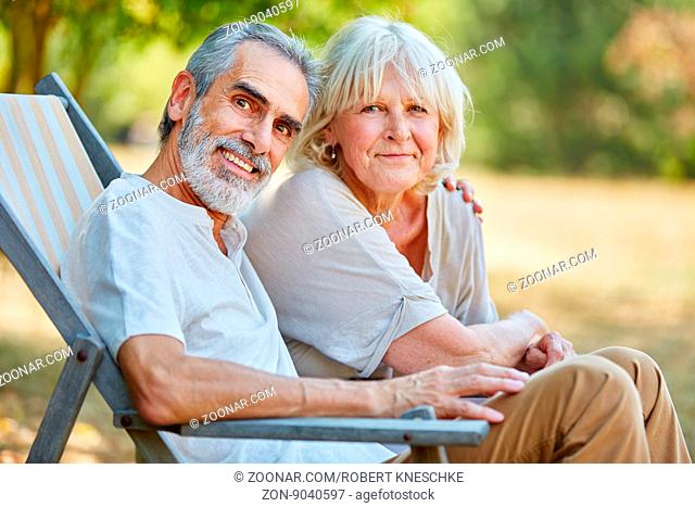 Senioren Paar sitzt glücklich im Liegestuhl im Sommer in der Natur