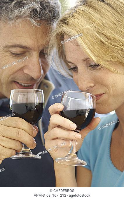 Close-up of a mid adult couple drinking red wine and smiling