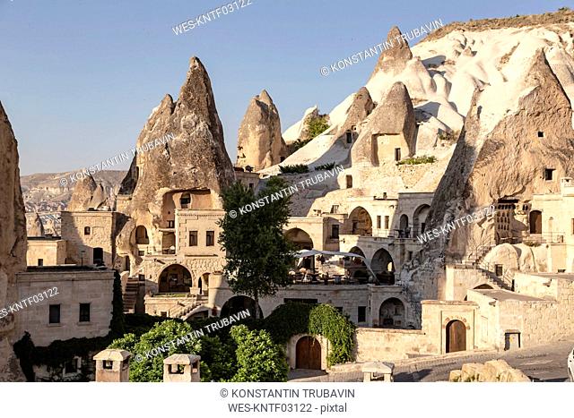 Houses and rock formations at GÇôreme city against clear sky, Cappadocia