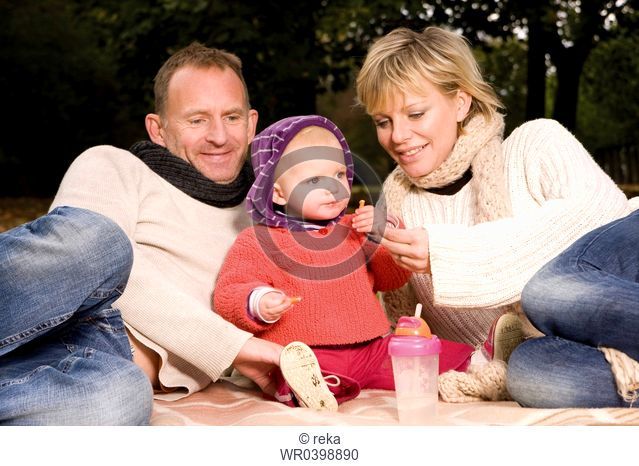 Family with toddler relaxing in park