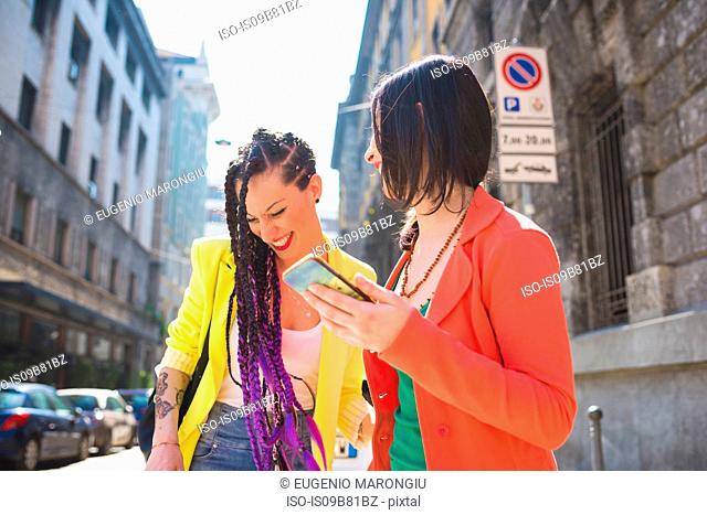 Women on city break using mobile phone, Milan, Italy