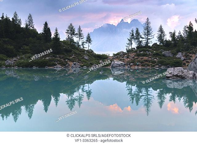 Cadini di Misurina surrounded by clouds reflect on the surface of Lake Sorapis. Cortina d'Ampezzo, Belluno province, Veneto, Italy