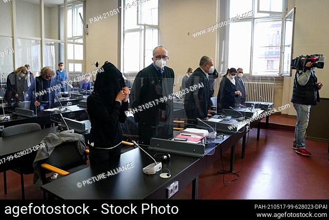 17 May 2021, Hamburg: The defendant (front) stands at the beginning of the trial in the courtroom, the co-defendant ""Billion Mike"" can be seen in the back...