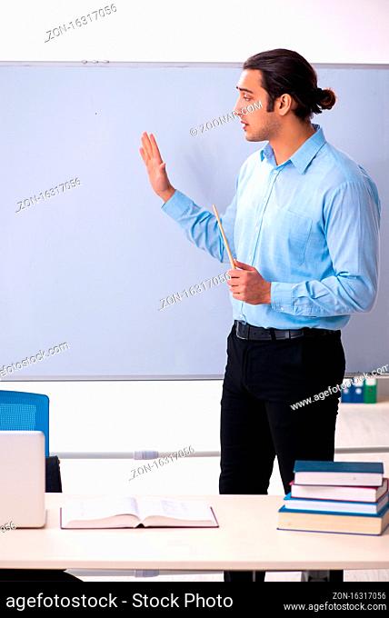 Young male teacher in front of whiteboard