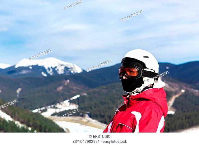 portrait of a skier standing on top of a mountain