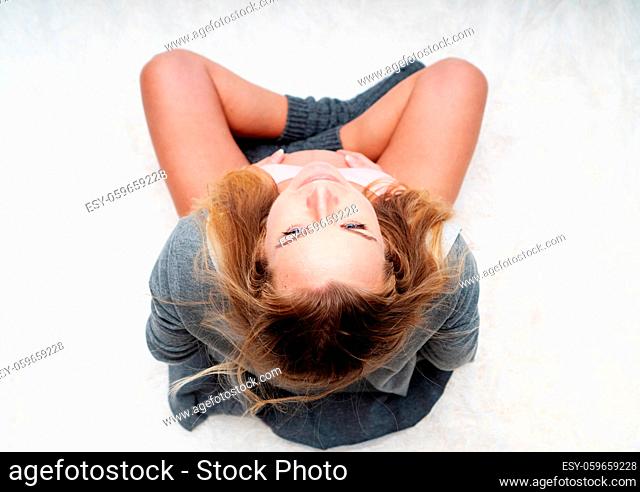 Top view image of pregnant woman holding, touching her belly while sitting on her bed at home. Maternity, pregnancy, new life and family planning concept