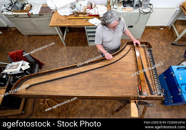 PRODUCTION - 16 May 2023, Saxony-Anhalt, Halle (Saale): Roland Hentzschel from the restoration studio at the Handel House in Halle/Saale examines a tangent...