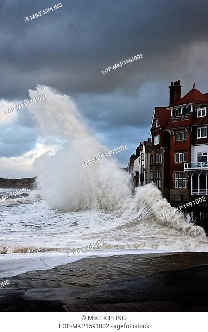 England, North Yorkshire, Sandsend. Rough North sea conditions create a spectacular sight as waves break against the seafront at Sandsend
