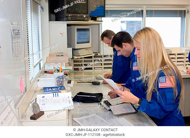 Astronauts Karen Nyberg, Greg Chamitoff (center) and Ron Garan, all STS-124 mission specialists, look over their flight plans in the check-out facility at...