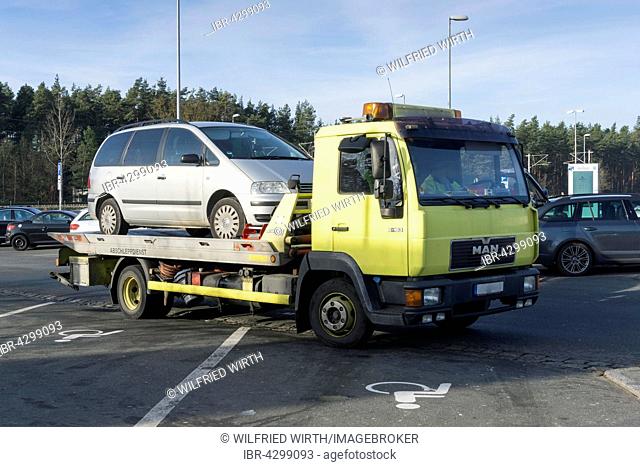 Car on tow-away vehicle, motorway lay-by, Bavaria, Germany