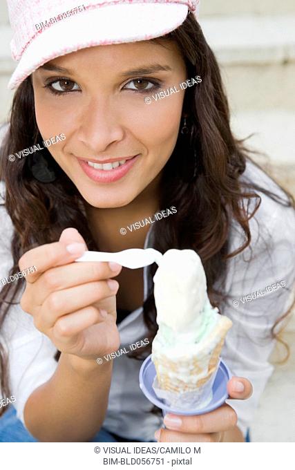 Hispanic woman eating ice cream cone