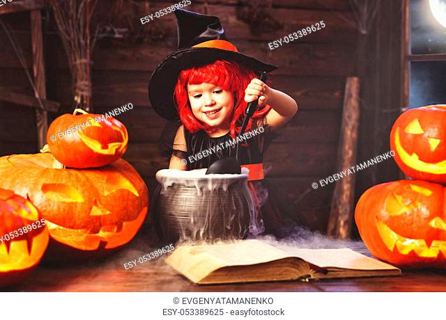 Halloween. little witch child cooking potion in the cauldron with pumpkin and spell book