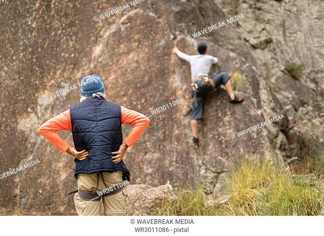 Man looking at his friend while climbing mountain