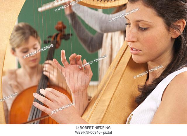 Germany, Emmering, Young women playing musical instruments