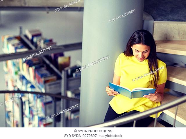 high school student girl reading book at library