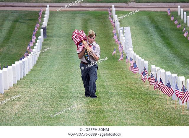 Boyscout places one of 85, 000 US Flags at 2014 Memorial Day Event, Los Angeles National Cemetery, California, USA