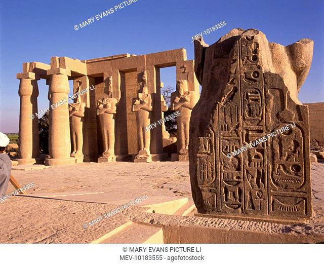The 'Ramesseum', Thebes (Luxor), Egypt, showing 4 Osiris posts and 2 Papyrus pillars of the 2nd Pylon, with the fallen statue of Rameses II beside them
