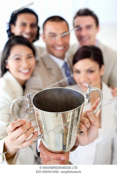 Successful business team showing their throphy in a company