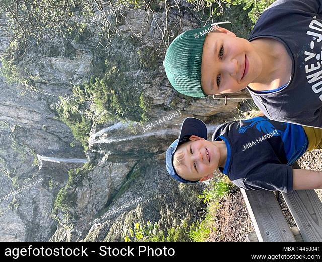 Two children at the waterfall near Scharnitz, nature, mountains, water, activity, region Seefeld, Leutasch, Mösern, Reith, Scharnitz, Tirols Hochplateau