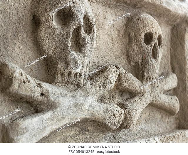 Ancient stone skull with crossbones. Old sculpture. Ideal for concepts and backgrounds