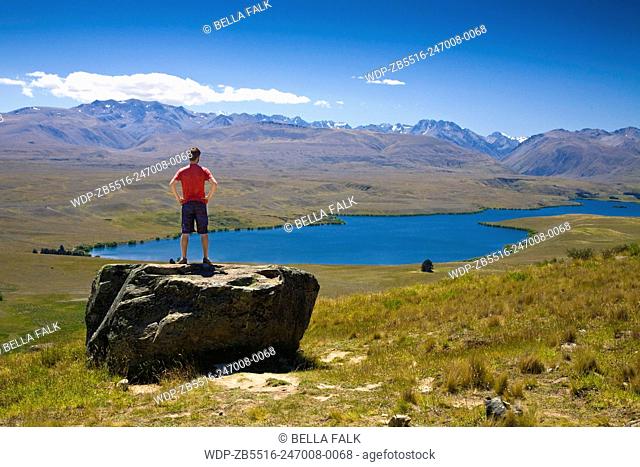 A young man looks out over Lake Tekapo, South Island, New Zealand, Model Released