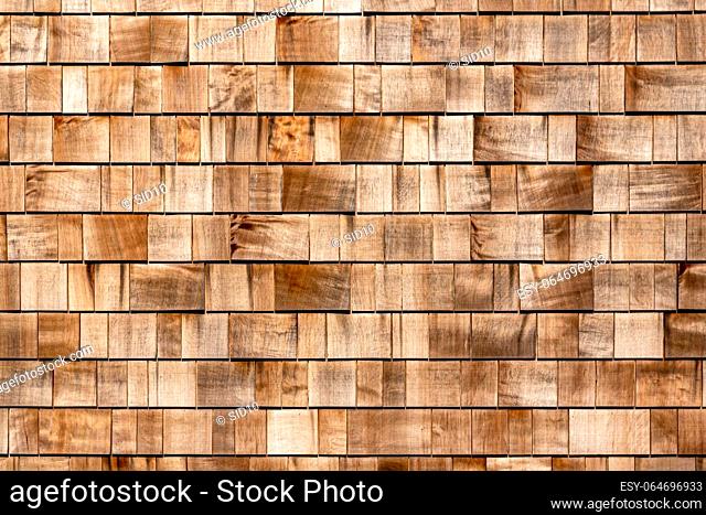 Shingle red cedar wooden shake wood siding row roof panel made of larch conifer tree. Wooden shingles background. Brown wood shingles background texture