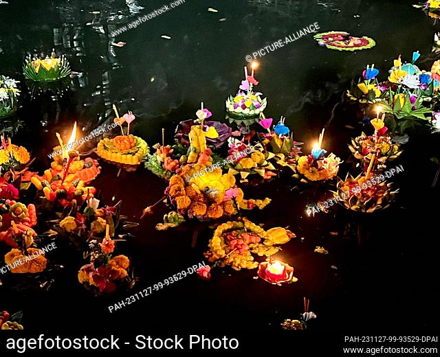 27 November 2023, Thailand, Bangkok: Krathongs float in a lake in Lumphini Park, one of Bangkok's largest parks. The small rafts are made of banana trees or...