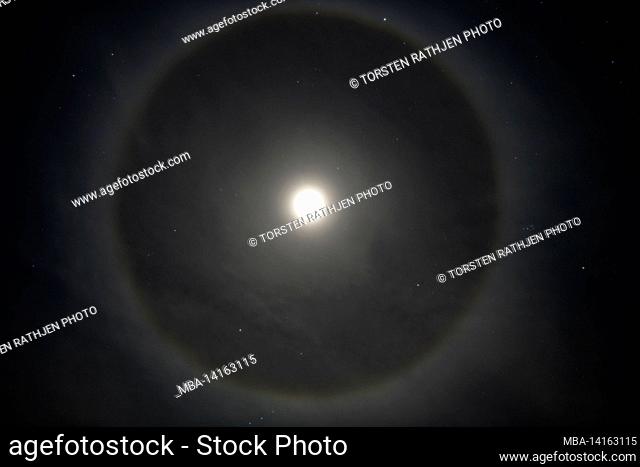 the full moon with a halo ring in the clear sky, småland, sweden