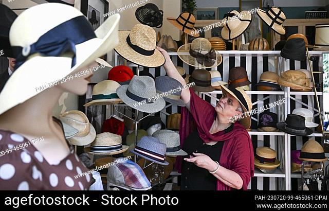 19 July 2023, Berlin: In her studio in the Günzelkiez in Wilmersdorf, milliner Petra Benz arranges Panama and summer hats