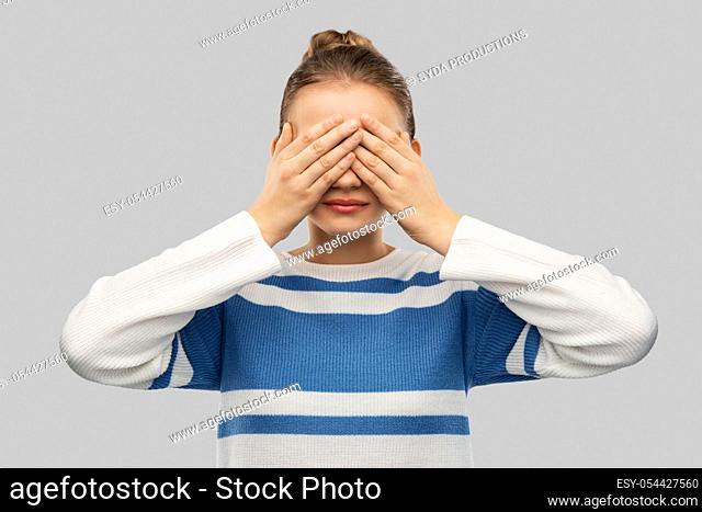 teenage girl closing eyes with hands