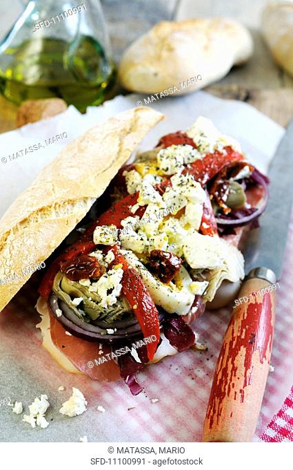 Ciabatta sandwich filled with Parma ham, red onions, sweet bell peppers, artichokes, sun dried tomatoes and feta cheese
