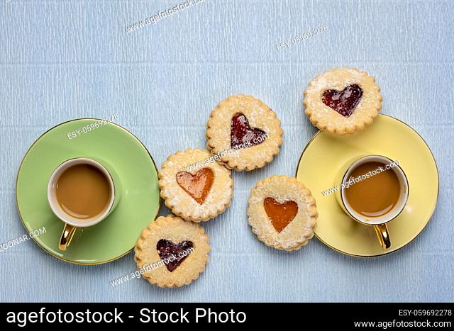 two cups of coffee with jam heart biscuits with a copy space, coffee break, dessert, love, romance or Valentine's Day concept