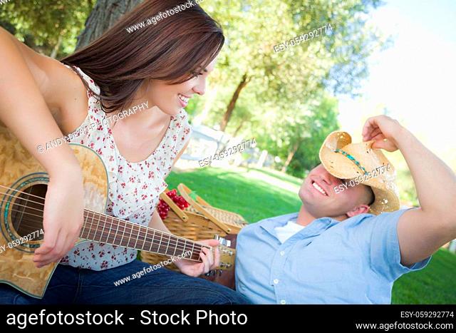 Happy Attractive Mixed Race Couple with Guitar and Cowboy Hat in the Park