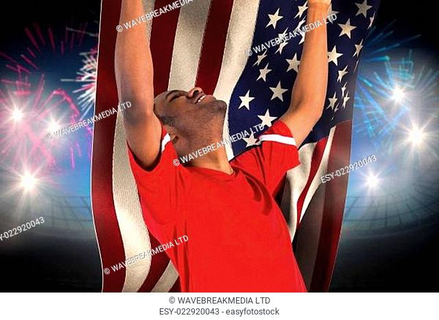 Excited handsome football fan cheering against fireworks exploding over football stadium and usa flag