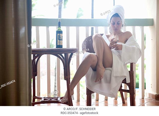 Young woman in bathing wrap, glass of wine, bath robe, towelling dressing gown