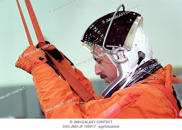 Astronaut Scott J. Horowitz, pilot, prepares to simulate a parachute drop into water during an emergency bailout training session at the Neutral Buoyancy...