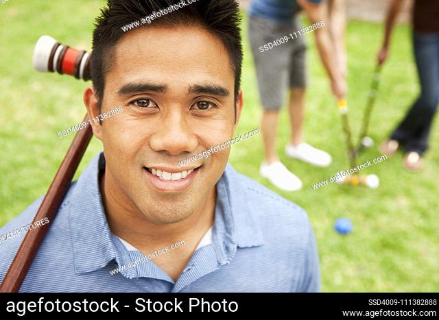 Smiling man holding croquet mallet