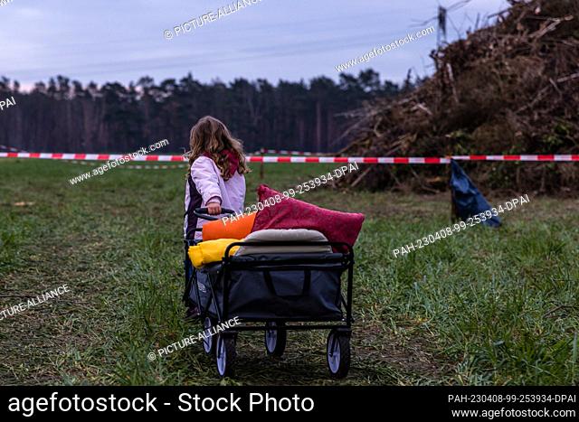 08 April 2023, Brandenburg, Cottbus: A girl pulls a handcart to the Branitz Easter fire, which has not yet been lit. The comrades of the volunteer fire...