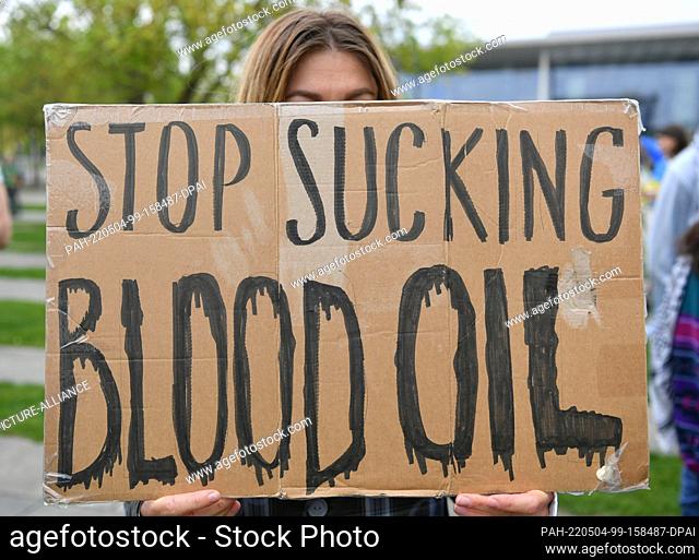 04 May 2022, Berlin: A participant in the protest action at the Federal Chancellery against the Russian invasion of Ukraine holds a sign