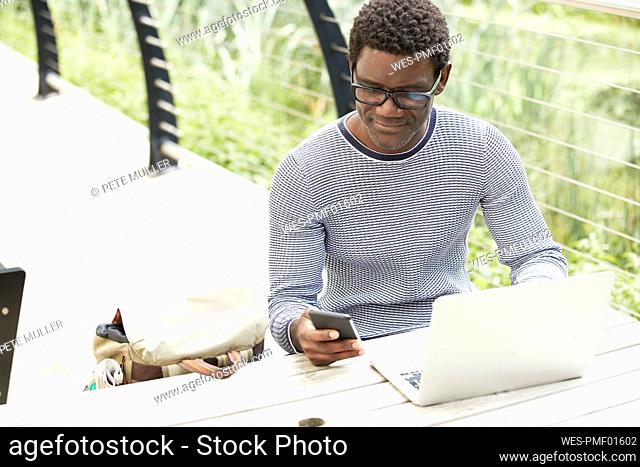 Businessman using mobile phone while sitting at table