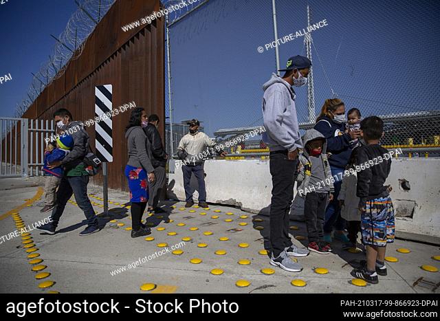 17 March 2021, Mexico, San Ysidro: Migrants from Central America and their children watch an exercise conducted by members of the US Border Patrol (CBP) at the...