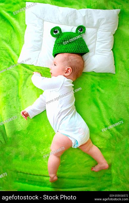 little boy lying on soft green blanket