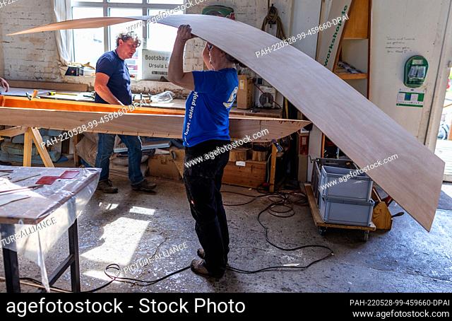 19 May 2022, Mecklenburg-Western Pomerania, Peenemünde: Boat builder Ursula Latus brings a plywood plate for the further construction of a canoe two-seater at...