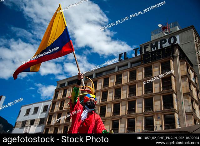 A demonstrator waves a Colombian national flag as Colombians demonstrate a t the start of the fifth week of anti-government protests against President Ivan...