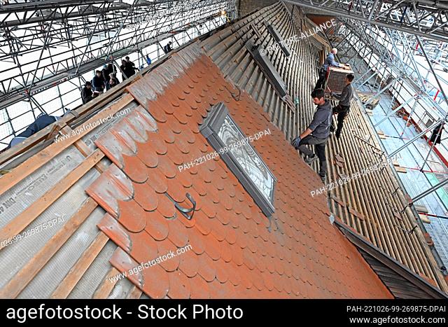 26 October 2022, Thuringia, Erfurt: Craftsmen work on the roof of the old convent building in the Ursuline Convent. With the completion of scaffolding