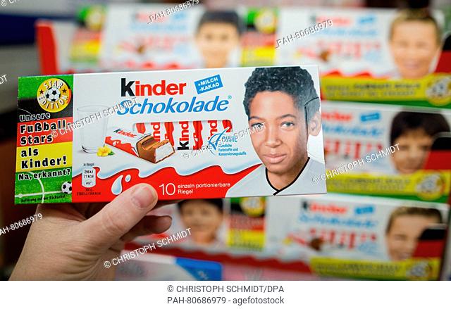 ILLUSTRATION - A woman holds a packet of Ferrero Kinder chocolates with a childhood photo of Jerome Boateng (l) in a supermarket in Fellbach, Germany